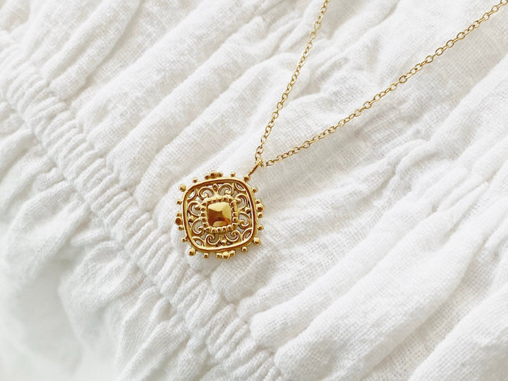 Goldene Edelstahl Medaillon Halskette mit Rauten Anhänger, weißes Baumwoll Kleid von Schmuck Online Shop Alicia&