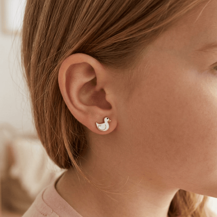 Kinder Ohrstecker mit weißer Ente getragen am Ohr eines kleinen Mädchens, Emaille Ohrringe Kinderschmuck online bestellen