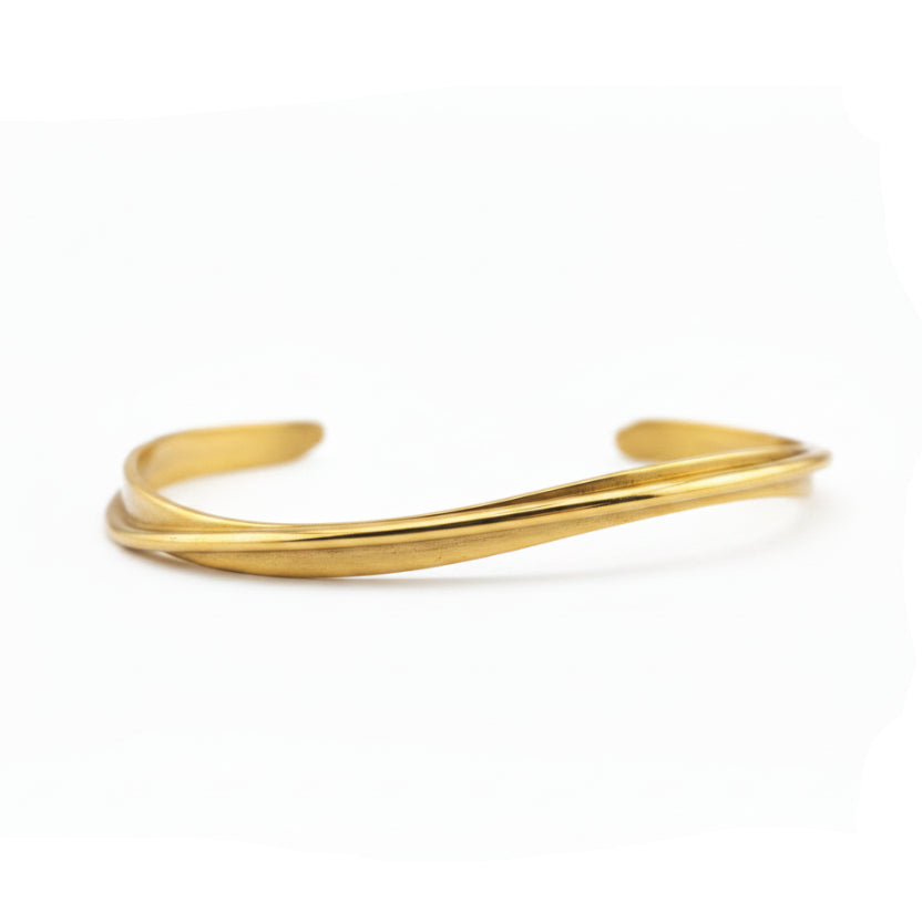 Shiny gold bangle against a white background