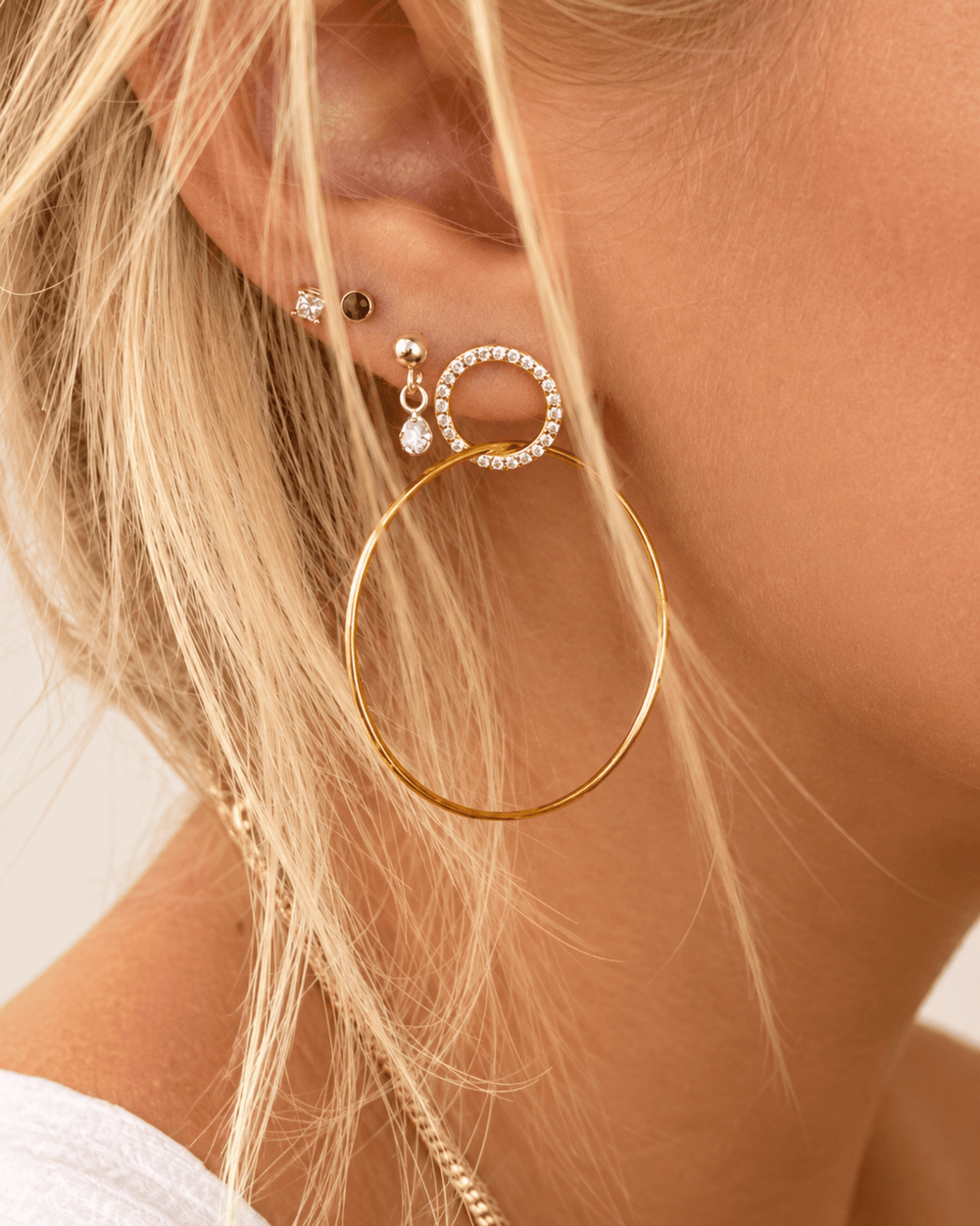 Große vergoldete Double Hoops mit funkelnden Zirkonen am Ohr getragen