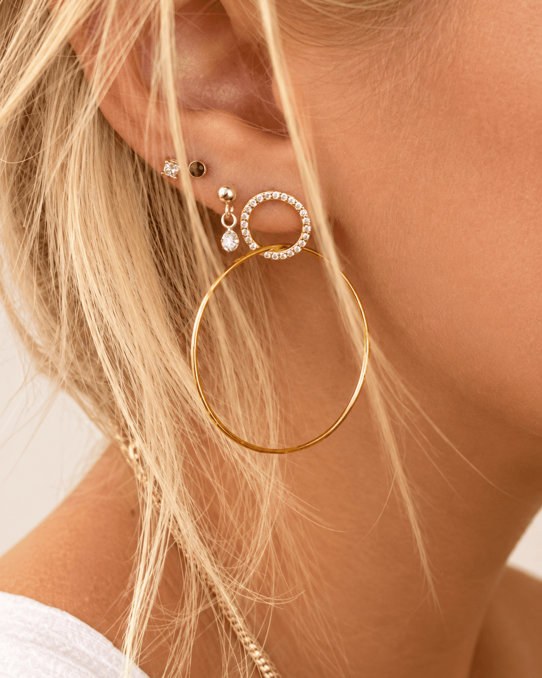 Große vergoldete Double Hoops mit funkelnden Zirkonen am Ohr getragen