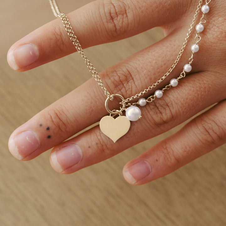 Detail von Goldschmuck mit Herz-Anhänger und Perlen, süße Kette für beste Freundin, Hochzeit
