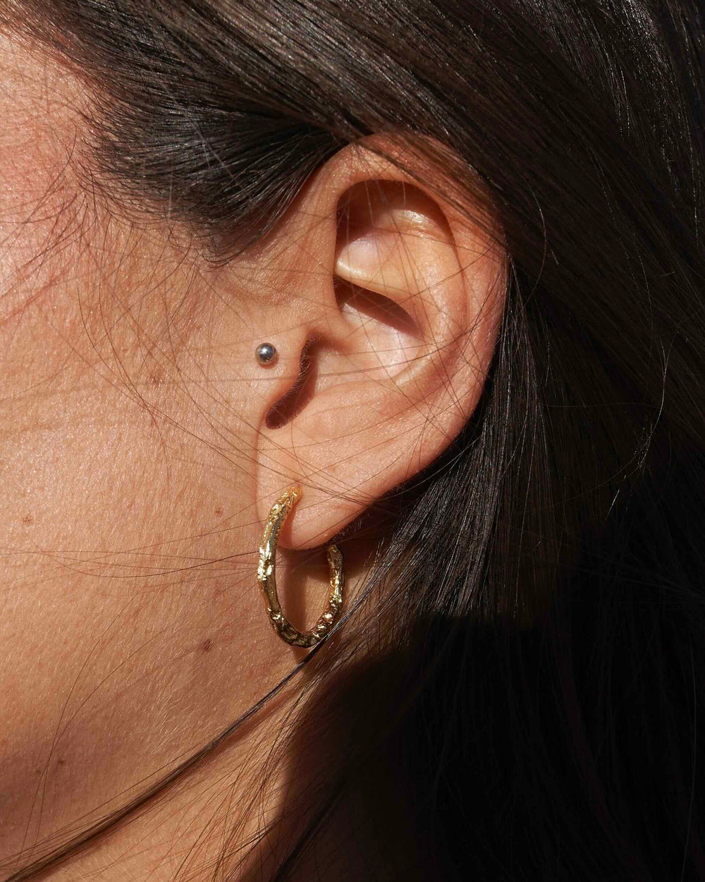 Aesthetic ear stacking inspiration, lobe, goldene Creolen mit Hammerschlag an dunkelhaariger Frau von Alicia's Diary