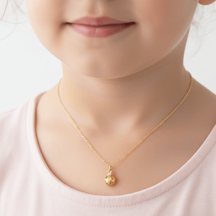 Marienkäfer Halskette gold mit Herz und Glitzerstein an Mädchen mit rosa Shirt, Schmuck von Alicia&