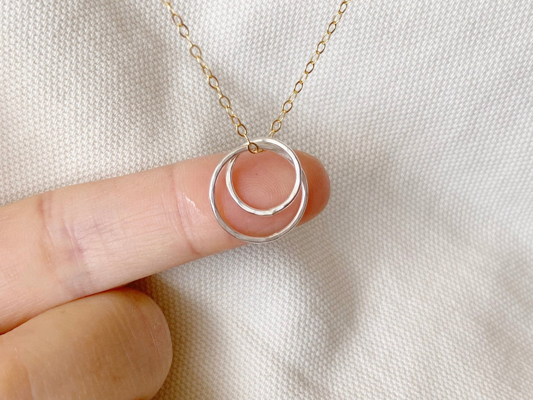 Bicolor: Zarte goldene Halskette mit silbernem Anhänger aus zwei verschlungenen Ringen von Alicia's Diary