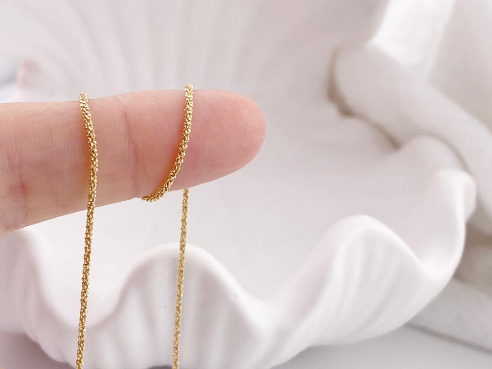 Goldene Basic Halskette auf Finger gewickelt