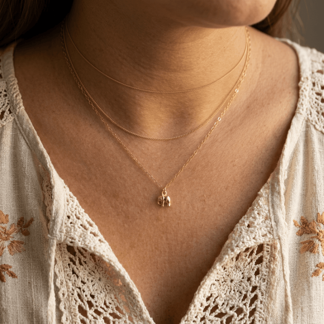 Goldene Elefanten Kette getragen zum weißen Boho-Spitzenkleid im mehrreihigen Look, hochwertigen Schmuck online bestellen