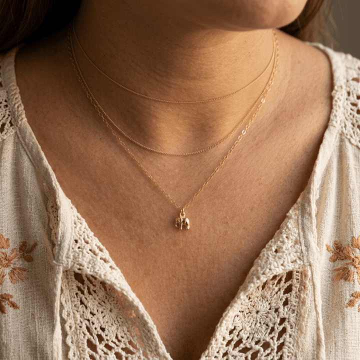 Goldene Elefanten Kette getragen zum weißen Boho-Spitzenkleid im mehrreihigen Look, hochwertigen Schmuck online bestellen