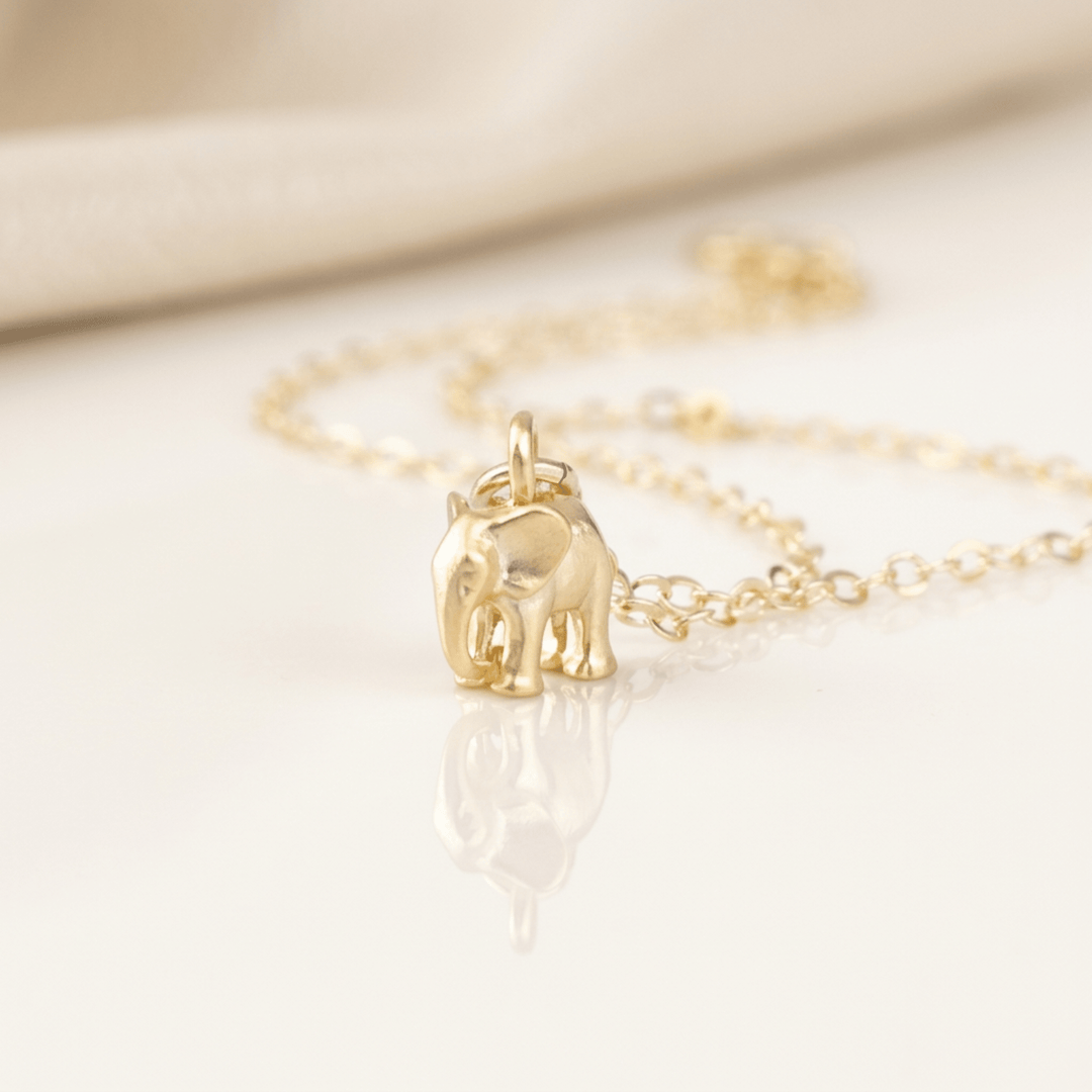 Nahaufnahme des goldenen Elefanten Charm mit feinen Kettengliedern, Halskette mit Elefanten Charm, naturgetreuer Elefant, Schmuck mit Elefanten gold online bestellen