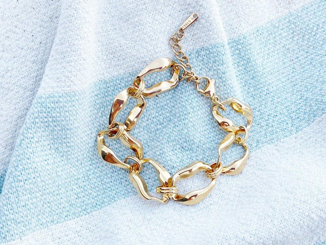 Goldenes Chunky Armband auf gestreiftem Strandtuch für Beach Girl Outfits, schöner Schmuck von Alicia's Diary