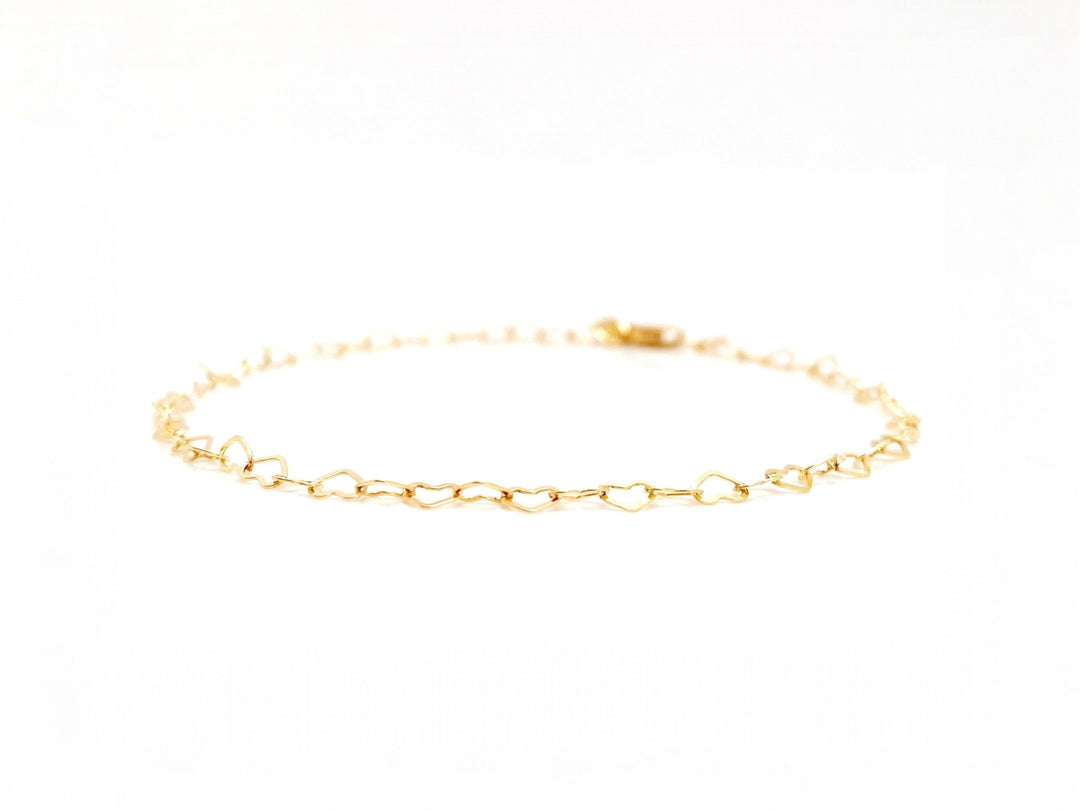 Goldenes Herz Armband vor weißem Hintergrund