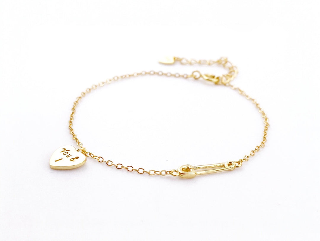 Goldenes Armband mit Herz auf weißem Hintergrund