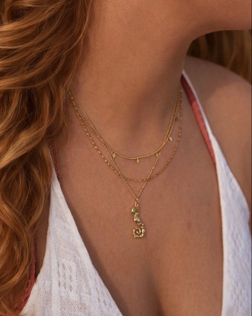 Halsketten Stack gold Inspiration mit weißem Häkelkleid und pinkem Bikini an Frau mit langen offenen Haaren, Schmuck von Alicia&