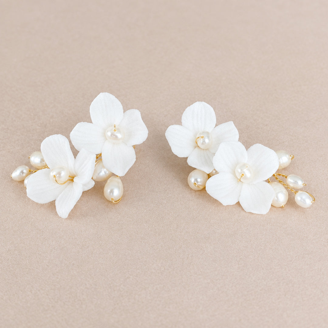 Pair of playful Sophie bridal earrings with white blossoms and pearls in gold