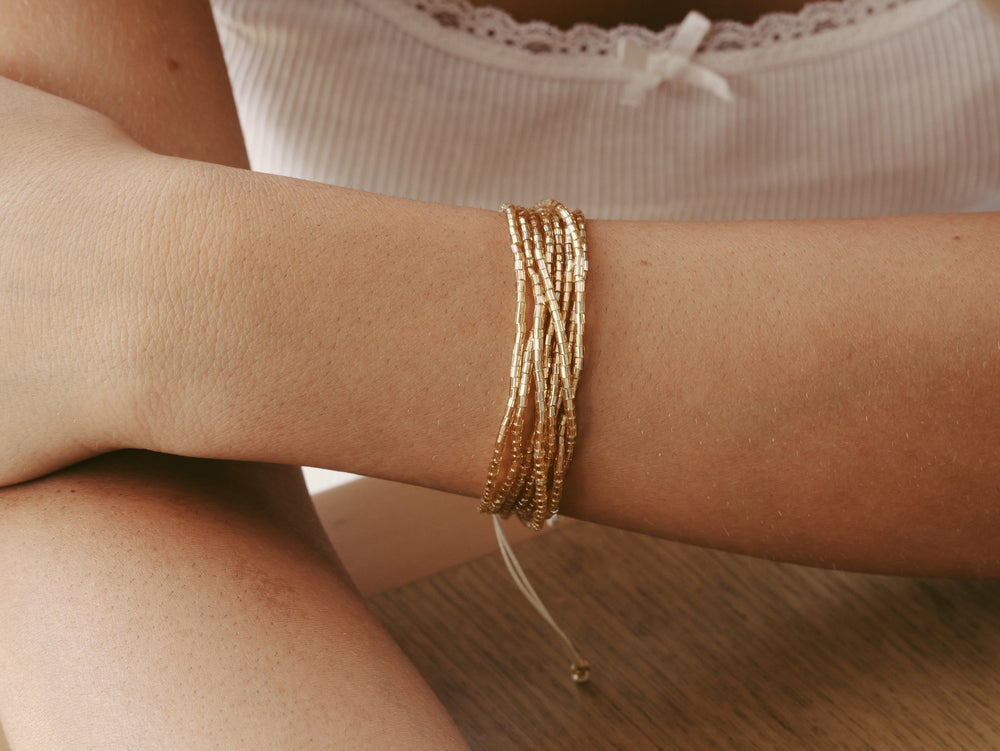 Miyuku Perlen Armband mit Glasperlen an Arm von schöner junger Frau mit weißem Spitzentop von Alicia's Diary