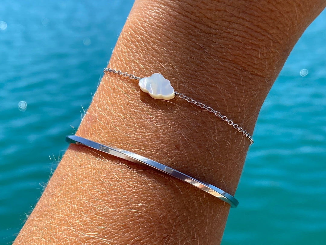 Silbernes armband mit Perlmutt Wolke und silbernem armreifen vor Meer