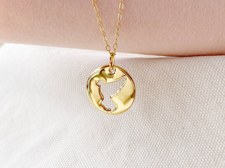 Minimalistische Friedenstaube auf Coin Anhänger an goldener Halskette von Alicia's Diary