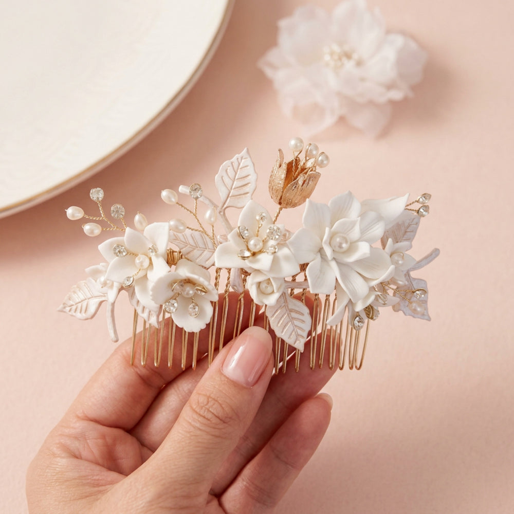 Brautkamm Marie mit weißen Blüten und Strasssteinen in der Hand gehalten