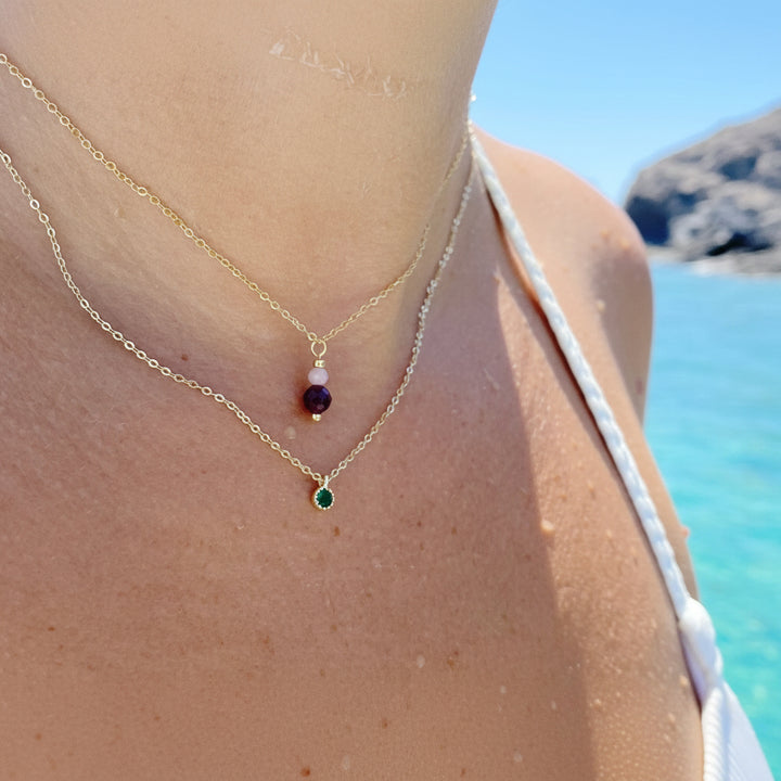 Dezente Halskette mit grünem Stein, rotem Granat Stein, feiner Silberschmuck gold an Frau mit weißem Bikini, Alicia&