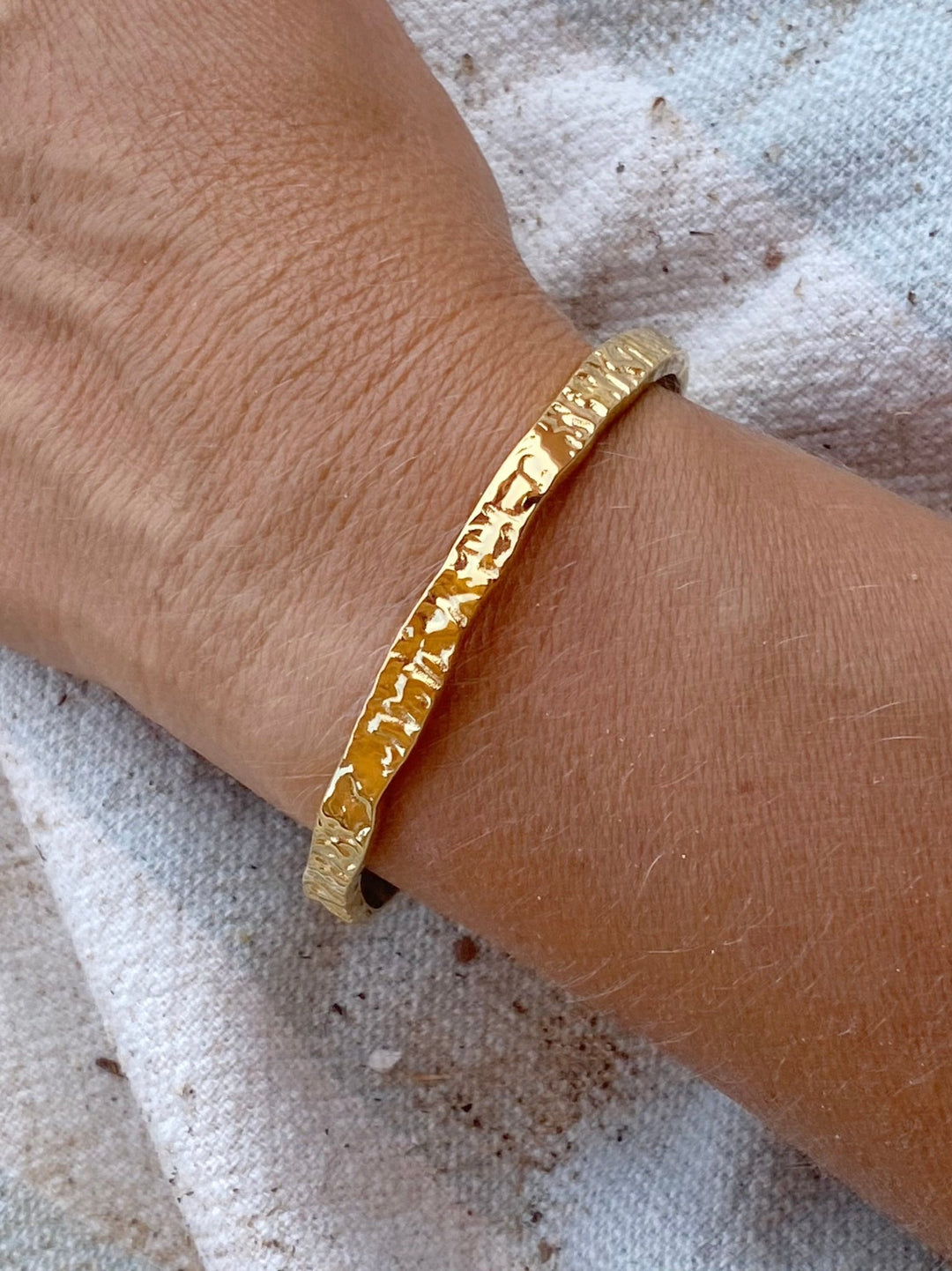 Gehämmerte goldene Armspange aus Edelstahl an Model - ALICIA'S DIARY®