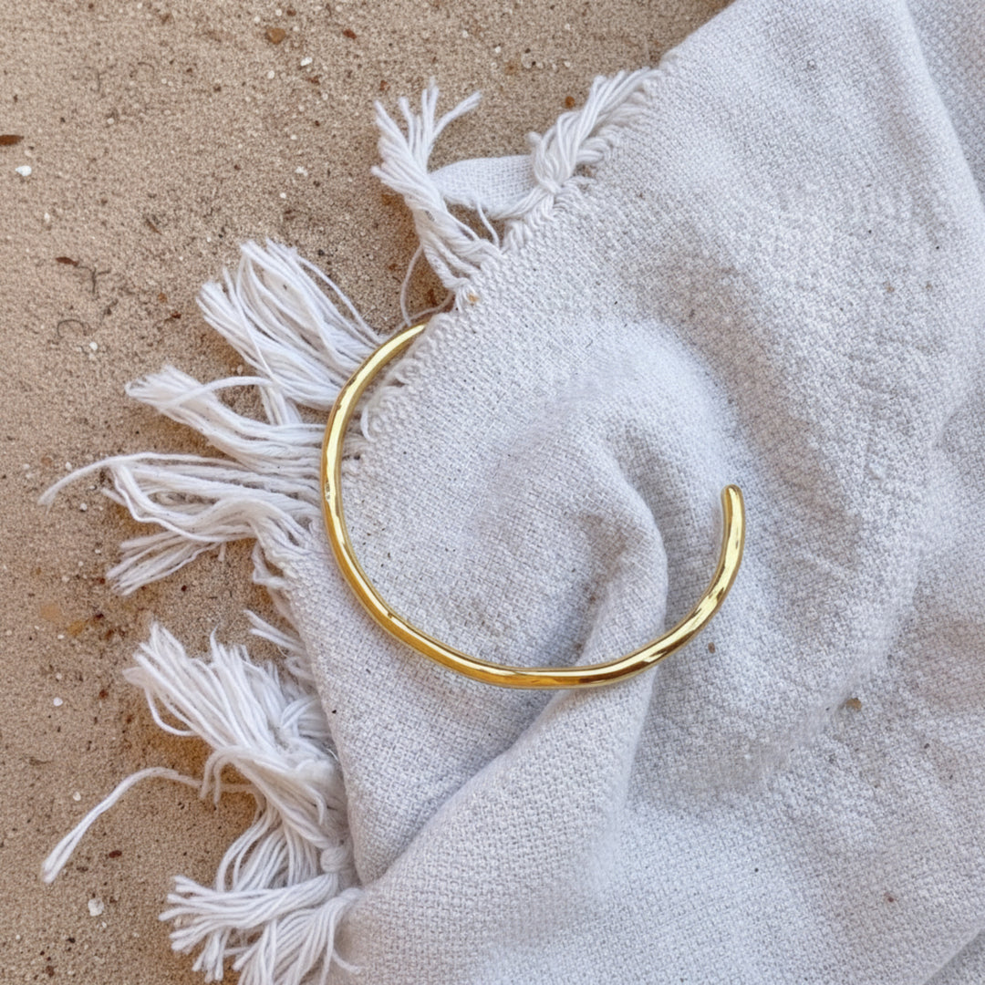 Brazalete ondulado dorado fabricado en acero inoxidable quirúrgico, resistente, impermeable y a prueba de arañazos, ideal para vacaciones y viajes.