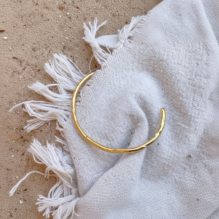 Brazalete ondulado dorado fabricado en acero inoxidable quirúrgico, resistente, impermeable y a prueba de arañazos, ideal para vacaciones y viajes.