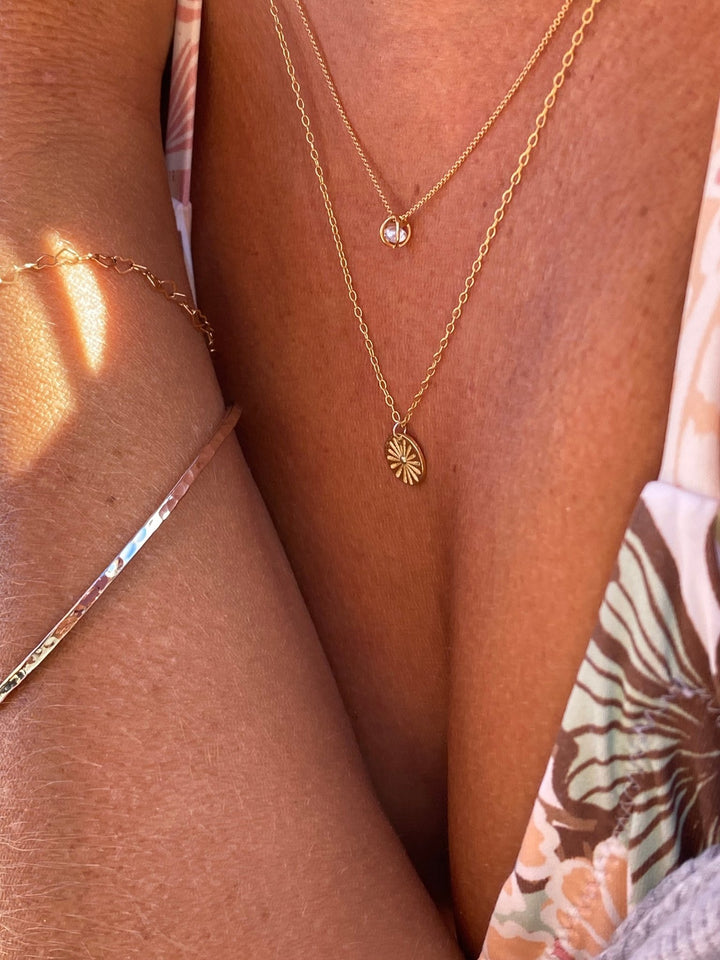 Layering Schmuck: Goldene Sonnenkette kombiniert mit weiteren Halsketten